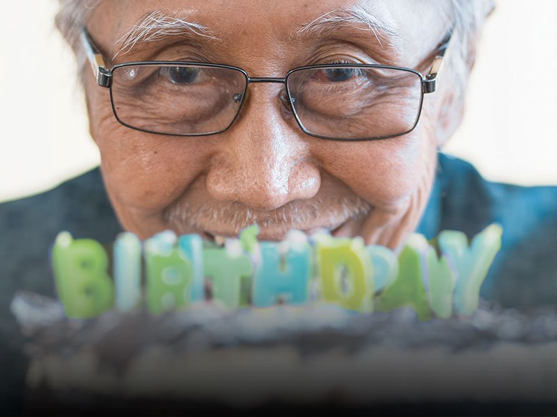 elderly man looking at birthday candles